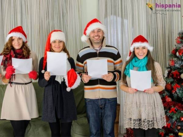 Personas cantando villancicos navideños. Hispania, escuela de español